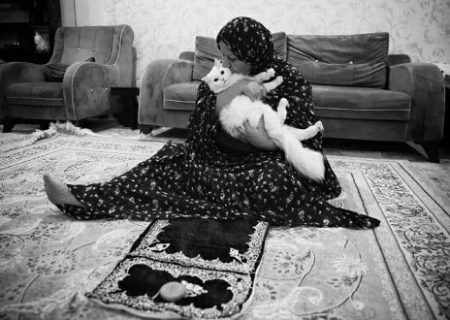 مادری که بعد از نماز، گربه‌اش را بغل می‌کند/عکس